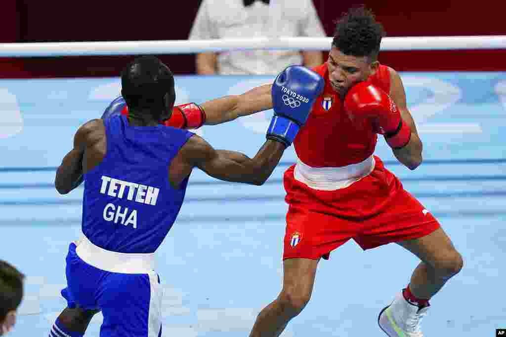 Cuba's Yosbany Vetia, right, exchanges punches with Ghana's Tettah Sulemanu during their men's flyweight 52-kg boxing match at the 2020 Summer Olympics, Saturday, July 31, 2021, in Tokyo, Japan. (AP Photo/Frank Franklin II)