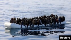 FILE - Migrants are seen in a rubber dinghy as they are rescued by the Libyan coast guard in the Mediterranean Sea off the coast of Libya, Jan. 15, 2018. Doctors Without Borders reported Monday that more than 100 migrants in two rubber boats died off the coast of Libya in early September.