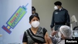 Una trabajadora de la salud recibe una dosis de la vacuna Sputnik V contra la enfermedad por coronavirus (COVID-19) en el Hospital del Norte en El Alto, afueras de La Paz, Bolivia, 30 de enero de 2021.