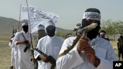 FILE - Followers of a breakaway Taliban faction holds their weapons at a gathering, in Zabul province, southern Afghanistan, Aug. 15, 2016. The Taliban assaulted Shamulzayi in Zabul province, May 15, 2019, killing at least 13 government soldiers.