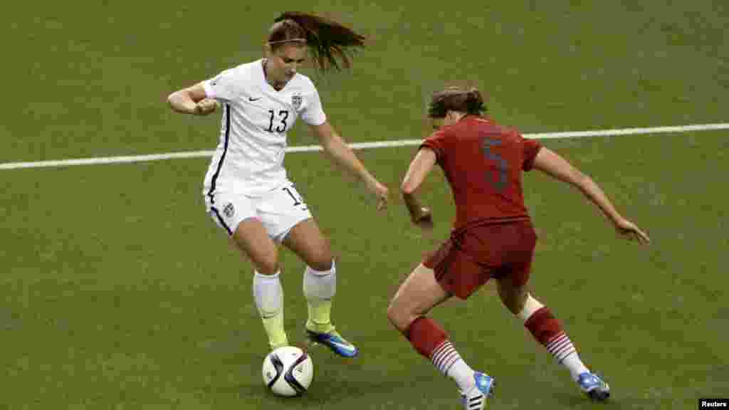 'Yar wasan Amurka Alex Morgan (13) ta yanke Annike Krahn na Jamus. 30 ga watan Yuni, 2015