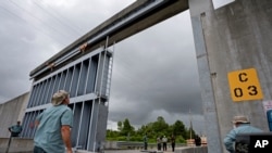 Trabajadores de la Autoridad de Protección contra Inundaciones del Sudeste de Louisiana cierran la esclusa de Bayou Road en la Parroquia de St. Bernard, el sábado 6 de junio de 2020, antes de la tormenta tropical Cristóbal.