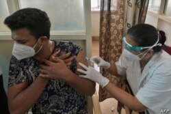 Un trabajador médico inocula a un hombre con una dosis de la vacuna contra el coronavirus COVID-19 en un hospital gubernamental en Bangalore, India, el 7 de mayo de 2021.