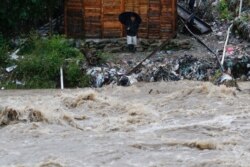 A man watches the rising water of the Rio Bermejo in the wake of Hurricane Iota in San Pedro Sula, Honduras, Nov. 17, 2020.