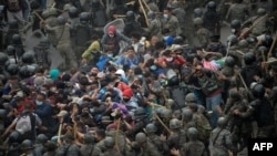 Migrantes hondureños, parte de una caravana que se dirigían a Estados Unidos, se enfrentan con las fuerzas de seguridad guatemaltecas en Vado Hondo, Guatemala, el 17 de enero de 2021. [AFP]
