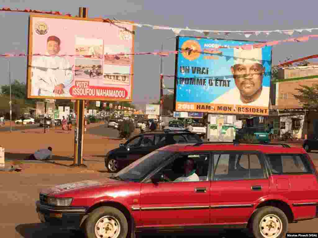 Les affiches des deux candidats à la présidentielle du dimanche, le président sortant Mahamadou Issoufou, et d’un de ses adversaires, Hama Amadou, trônent sur un carrefour de Niamey, Niger, 17 février 2016. (VOA/Nicolas Pinault).