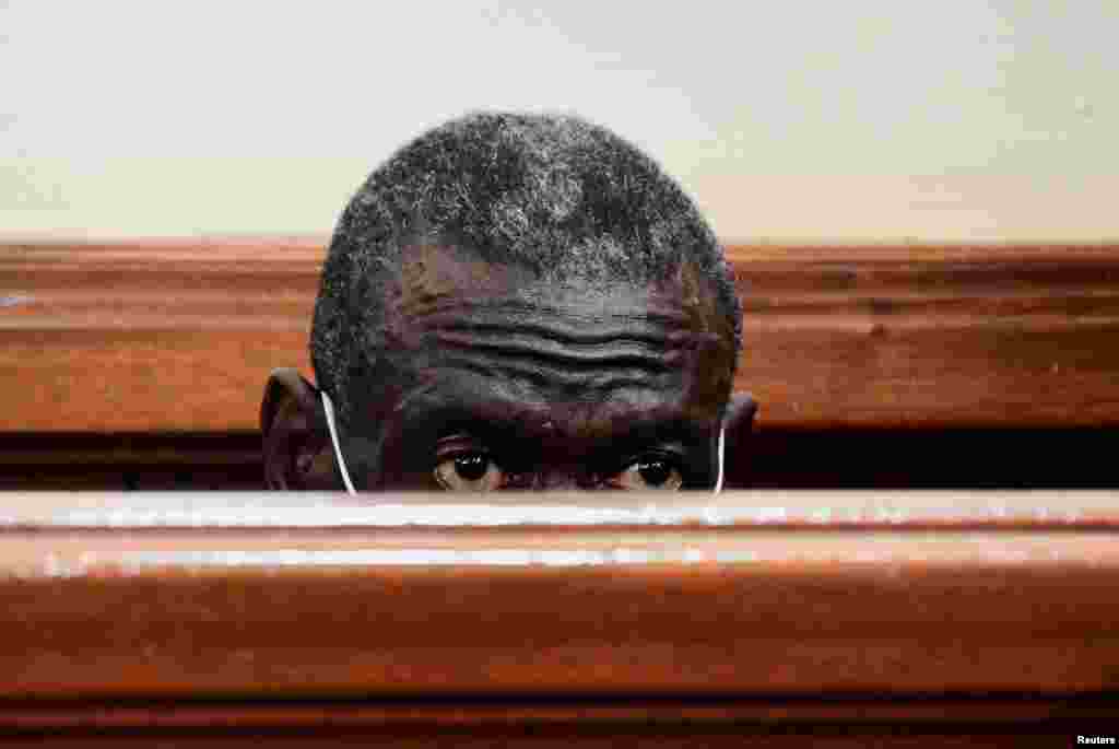 Uganda's four-time presidential candidate Kizza Besigye sits in the dock where he was charged with treason, at the Chief Magistrate Court in Nakawa suburb of Kampala, Uganda. REUTERS/Abubaker Lubowa