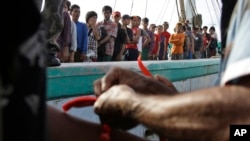 Government official puts wrist bands on recently rescued Burmese fishermen for identification purposes upon their arrival in Tual, Indonesia, April 4, 2015.