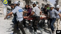 Sept. 21, 2016, file photo, provided by the Syrian Civil Defense White Helmets, rescue workers work the site of airstrikes in the al-Sakhour neighborhood of the rebel-held part of eastern Aleppo, Syria.