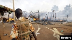 Wani sojan kungiyar SPLA yake tafiya kusa da kasuwar da jiragen saman yakin Sudan suka lalata kusa da Benitiu.