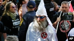 Un membre du Ku Klux Klan escorté par la police lors d'une manifestation à Charlottesville, le 8 juillet 2017.