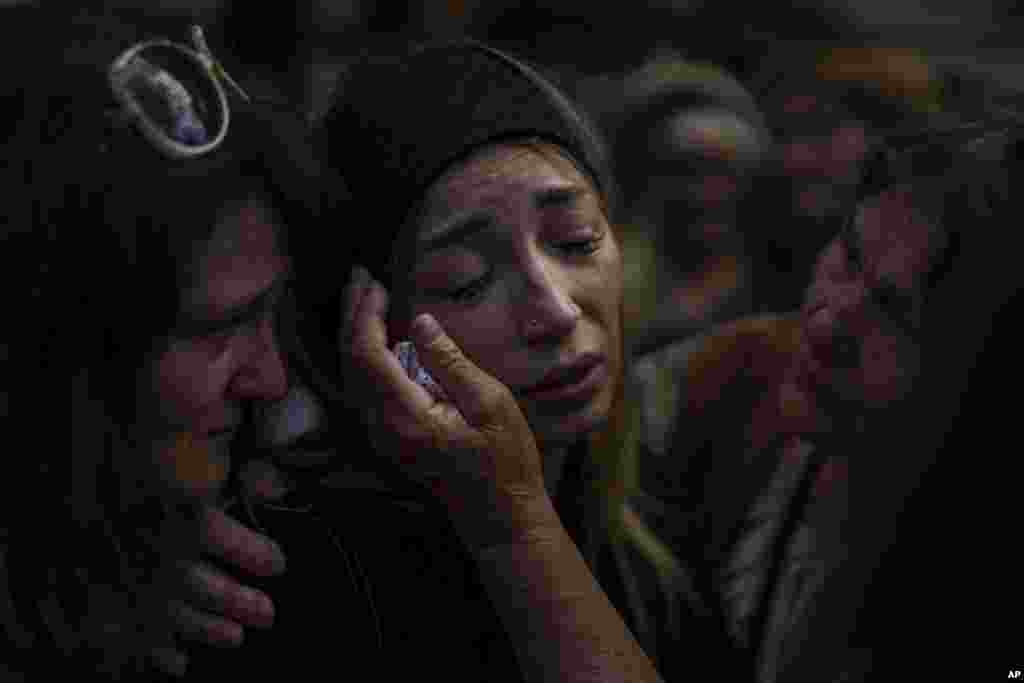 Anastasia Ohrimenko, de 26 años, es consolada por familiares mientras llora junto al féretro de su esposo, Yury Styglyuk, un soldado ucraniano que murió en combate el 24 de agosto, en Maryinka, Donetsk, durante su funeral en Bucha, Ucrania, el 31 de agosto de 2022.