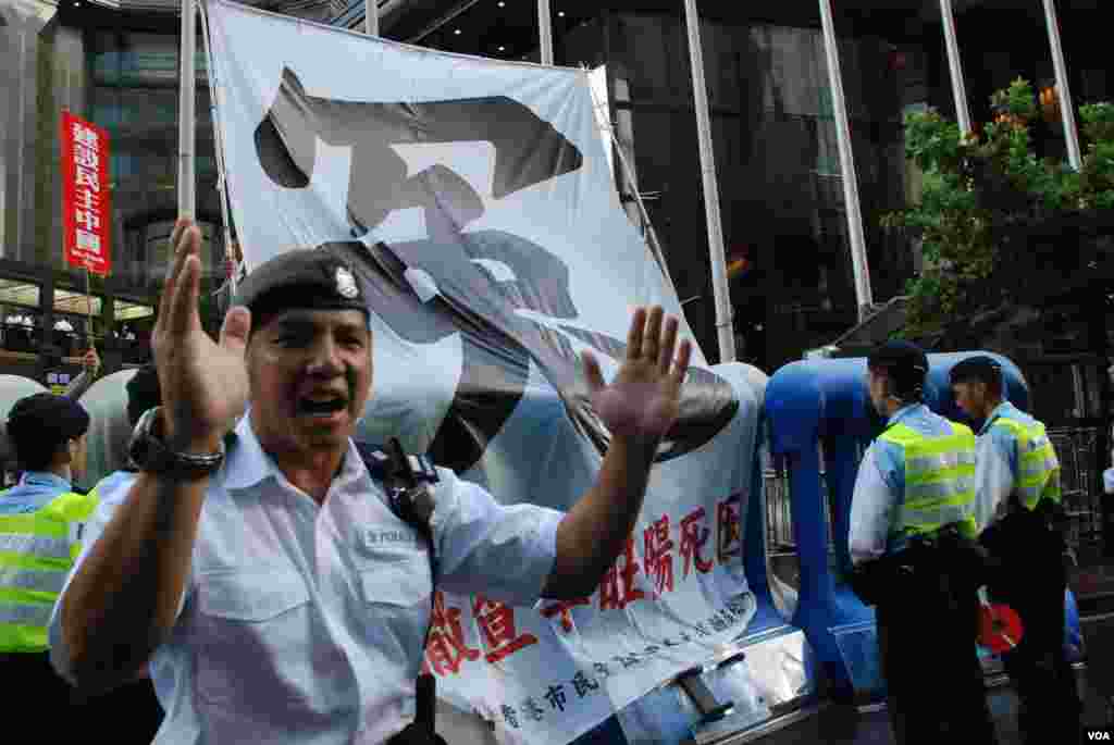 示威者將一幅巨型「冤」字布幅掛出示威區,大批警員戒備,又勸喻記者不要接近示威區