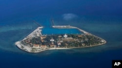 FILE - The Vietnamese-claimed Southwest Cay island in the Spratly island group is seen from a Philippine Air Force C-130 transport plane during the visit to the Philippine-claimed Thitu Island by Defense Secretary Delfin Lorenzana, Armed Forces Chief Gen.