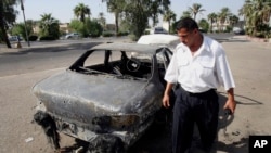 Seorang polisi lalu lintas Irak memeriksa mobil yang hancur ditembak tentara bayaran dari kontraktor keamanan swasta, Blackwater, di al-Nisoor Square, Baghdad, Irak, 25 September 2007. 