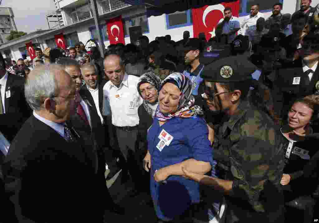 The leader of Turkey's main opposition Republican People's Party (CHP) Kemal Kilicdaroglu (left) pays his condolences to Hulya Aydin, the mother of Turkish police special operations officer Sahin Polat Aydin, one of the four officers killed Monday in a landmine attack, Ankara, Turkey, Aug. 11, 2015.