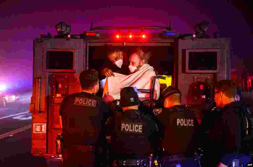 Elderly patients are quickly evacuated into an armored vehicle as embers and flames approach during the Eaton Fire in Pasadena, California, Jan. 7, 2025.