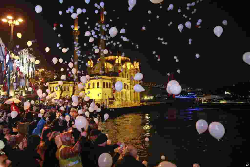 People release balloons and lanterns in the air in Istanbul's Ortakoy district by the Bosphorus, during New Year's cerebrations, Jan. 1, 2017.