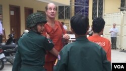 អ្នកផលិត​ភាពយន្ត​​ឯកសារ​សញ្ជាតិ​អូស្រា្តលី​ ​លោក​​ James Ricketson​ ​ដែល​មន្ត្រី​ជាន់​ខ្ពស់​របស់​រដ្ឋាភិបាល​កម្ពុជា​ចោទ ថា ​ជា​​អ្នកផ្តល់​ព័ត៌មាន​សម្ងាត់​ដល់​លោក​ ​សម រង្ស៊ី​ ​ត្រូវ​បាន​មន្ត្រី​ពន្ធនាគារ​នាំ​យក​​មក​បង្ហាញ​ខ្លួន​ ​នៅ​តុលាការ​កំពូល​នៅ​ព្រឹក​ថ្ងៃពុធ​ ទី១៧ ខែមករា ឆ្នាំ២០១៨។ (ហ៊ុល រស្មី/VOA)