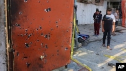 Warga setempat melihat tempat kejadian setelah terjadi ledakan di sebuah daerah komersial yang sibuk di Baghdad, Irak (13/7).