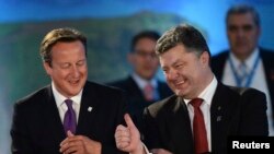 Presiden Ukraina Petro Poroshenko (kanan) dan PM Inggris David Cameron berbincang-bincang dalam diskusi mengenai NATO-Ukraina di Celtic di Newport, Wales, (4/9/2014).