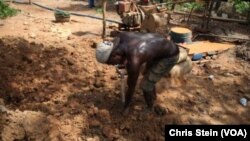 Un mineur creuse à l’aide d’une pelle dans une petite mine à Atunso, Ghana, 16 octobre 2014.