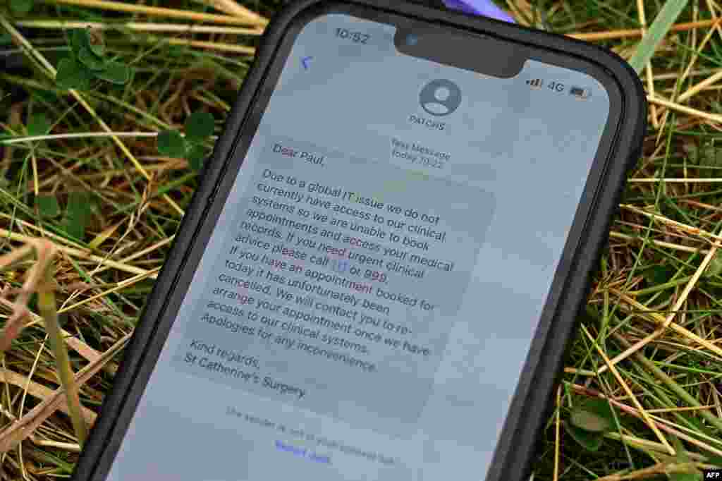 Se muestra una alerta por mensaje de texto en un teléfono móvil sobre la consulta de un médico del British NHS en Wirral, alertando a un paciente de que debido a un "problema de TI global" no tiene acceso a sistemas clínicos, sistemas de reserva o registros médicos de pacientes, cerca de Prestwick, suroeste de Escocia, el 19 de julio de 2024.