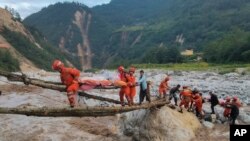 En esta imagen, distribuida por la agencia noticiosa Xinhua, rescatistas trasladan a sobrevivientes al otro lado de un río luego de un sismo en la localidad de Moxi, en el condado de Luding de la provincia de Sichuan, en el suroeste de China, el 5 de septiembre de 2022. 