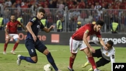 Oualid Azaro (C) d'Ahly, aux côtés du gardien Moez Ben Cherifia (R) et de Chamseddine Dhaouadi (L), lors de la finale de la CAF Champions League opposant les Egyptiens Al-Ahly et l'ES Tunisien, au stade Borg el-Arab près du Ville méditerranéenne d'Alexandie le 2 novembre 2018.