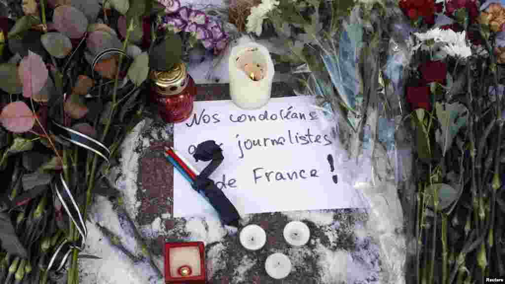 Des bougies, des fleurs de condoléances et des crayons sont déposés à l'extérieur de l'ambassade française à Kiev, our les victimes de la fusillade à Charlie Hebdo, le 8 janvier 2015.