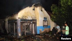 Pengikut aliran minoritas Islam Ahmadiyah memadamkan masjid yang terbakar di Desa Ciampea, Jawa Barat, 1 Oktober 2010. (Foto: Reuters)