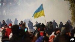 Протестующие в грузинской столице. Полиция применяет слезоточивый газ. В руках у одного из демонстрантов – флаг Украины. Тбилиси, 2 декабря 2024 г.