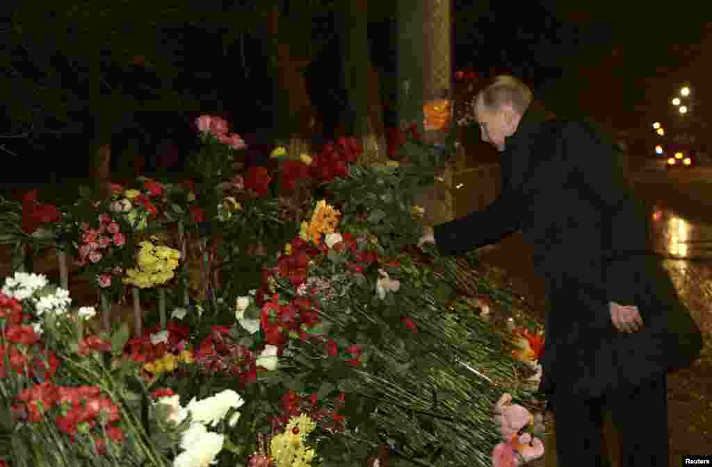 Russian President Vladimir Putin lays flowers at the site of a trolley bus explosion, Volgograd, Russia, Jan. 1, 2014.