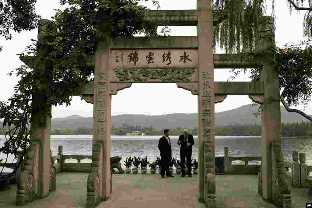 2006年9月19日,美国财政部长保尔森和中共浙江省委书记习近平在杭州西湖旁边刘庄的 “水秀云锦”牌坊下散步