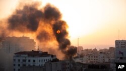 Una columna de humo sale de un edificio derrumbado después que fuera impactado por ataques aéreos de Israel en la Ciudad de Gaza el miércoles 12 de mayo de 2021. 