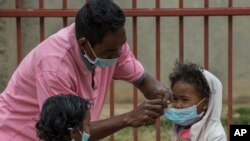 Des masques sont placés sur des enfants à Antananarivo, Madagascar, le 3 octobre 2017. À l'époque, les autorités sanitaires tentaient de contenir une épidémie de peste. (AP Photo/Alexander JOE)