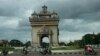 ປະ​ຊາ​ຊົນ​ຂອບ​ລົດ​ຜ່ານ​ປະ​ຕູ​ໄຊ, ນະ​ຄອນຫຼວງ ວຽງ​ຈັນ, ລາວ, 24 ກໍ​ລະ​ກົດ, 2024. (AP Photo/Sakchai Lalit)