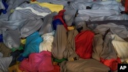 Migrants and refugees rest on the deck of a ship after being rescued, in the Mediterranean Sea off the coast of Libya.