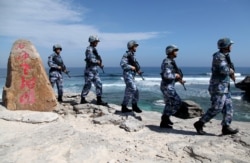 FILE - Soldiers of China's People's Liberation Army (PLA) Navy patrol at Woody Island, in the Paracel Archipelago, Jan. 29, 2016.