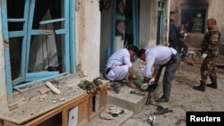 Afghan officials inspect the site of a suicide bomb attack outside a Shi'ite mosque in Herat, Afghanistan, March 25, 2018. 
