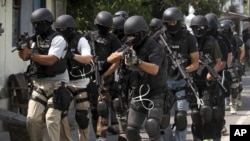 Members of Indonesian police anti-terror unit Special Detachment 88 move into positions as they prepare for a raid in Solo, Central Java, Indonesia, September 26, 2012.