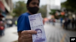 Una mujer muestra un nuevo billete de 500.000 bolívares luego de retirarlo de un banco en Caracas, Venezuela, el martes 16 de marzo de 2021. 