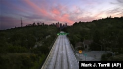 FILE - In this April 26, 2020, file photo, empty lanes of the 110 Arroyo Seco Parkway that leads to downtown Los Angeles is seen during the coronavirus outbreak in Los Angeles, Calif. (AP Photo/Mark J. Terrill, File)