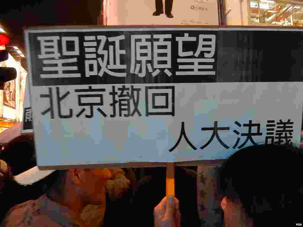 有「購物團」人士高舉聖誕願望標語,要求中國全國人大常委會撤回8-31落閘決定