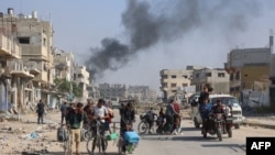 FILE - Palestinians displaced from shelters in Beit Hanoun cross the main Salaheddine road into Jabalia in the northern Gaza Strip on bicycles and tuk-tuks following Israeli army evacuation orders on Nov. 12, 2024.