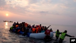 Des volontaires aident des migrants et des refugies qui ont réussi à traverser le mer Aggée en provenance de la Turquie, à Lesbos, Grèce, 20 mars 2016. 