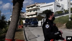 A police truck carries the car of a veteran Greek crime reporter in southern Athens, April 9, 2021. Giorgos Karaivaz was gunned down Friday near his home, police said.