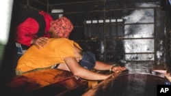 Los familiares lloran sobre los ataúdes con los restos de los mineros que murieron en el derrumbe de una mina de oro en El Callao, Venezuela, el 3 de junio de 2023.