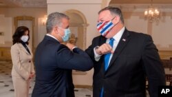 En esta fotografía de la Oficina de Prensa Presidencial de Colombia, el presidente Iván Duque y el secretario de Estado de los Estados Unidos, Mike Pompeo, se codean antes de su reunión en la casa presidencial en Bogotá, el 19 de septiembre de 2020.
