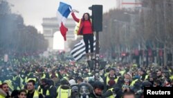 Fransa sürücülərinin simvolu olan sarı jilet geyinmiş nümayişçi Parisin Şanzelize prospektində hökumətin yanacaq vergisinin artırılması qərarına etiraz edir.